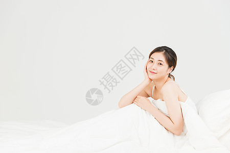 年轻女性坐床上休息图片