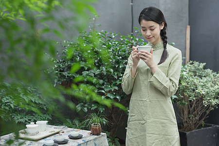茶桌喝茶手捧茶杯的美女背景