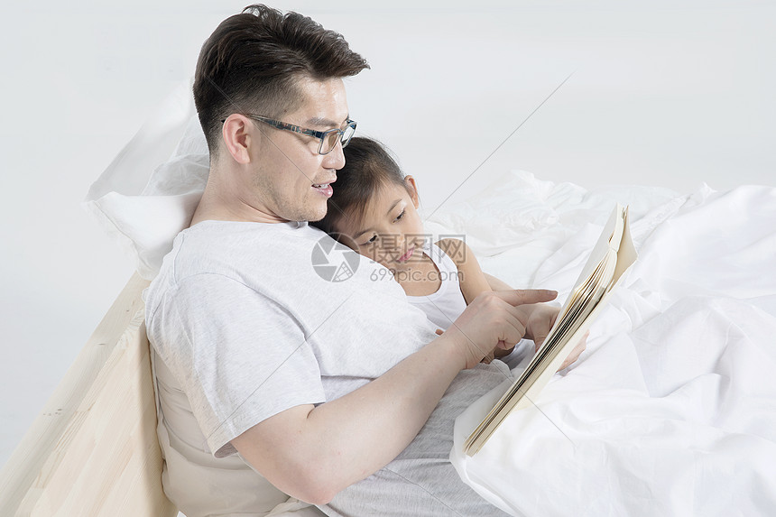 爸爸给女儿在床上讲故事图片