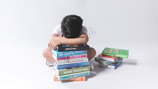 学习小学生小孩子在书堆中疲劳困扰背景