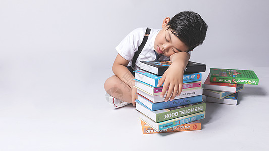 小孩子在书堆中疲劳困扰背景图片