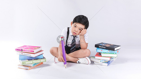 小孩子在书堆中疲劳困扰图片