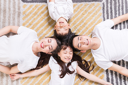 幸福的一家人躺在地毯上图片