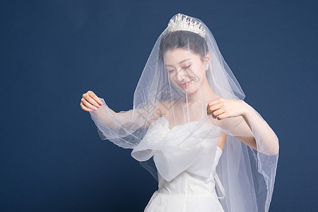 头戴头纱穿婚纱的新娘背景图片