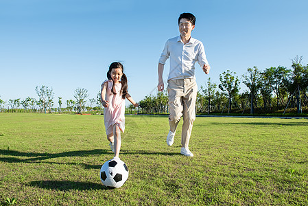 爸爸与孩子户外踢足球图片