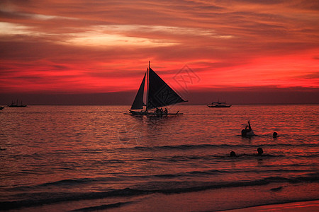 夕阳海滩海边帆船启航背景