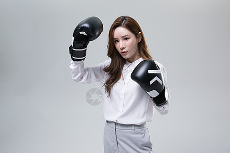力量击打打拳击的白领美女背景