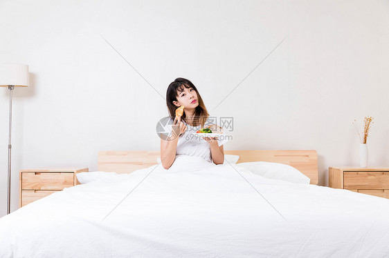在床上吃早餐的女孩图片