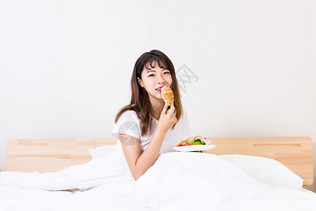 在床上吃早餐的女孩高清图片