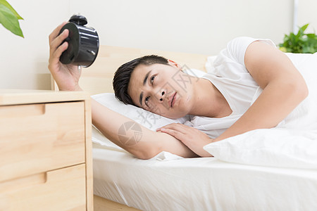 男性睡觉被闹钟吵醒背景图片