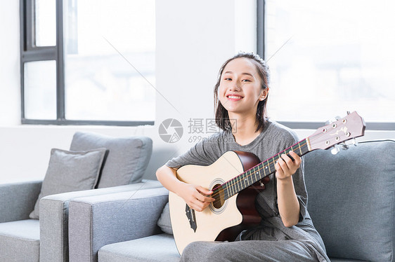 文艺青年沙发上弹吉他图片
