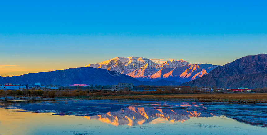 落日照雪山倒影图片