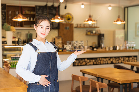 年轻咖啡馆服务员欢迎手势图片