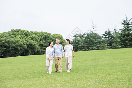 草地上幸福一家人散步图片