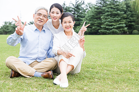 比耶做手势草地上幸福依靠的一家人背景