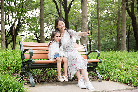 儿童风车妈妈和女儿在公园玩背景