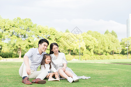 一家人坐在草坪背景图片