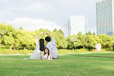 公园的草地上看手机高清图片草地上幸福一家人看手机高清图片草地上