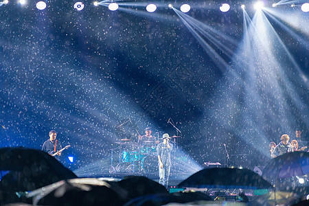 撑伞的观众大雨滂沱中的音乐节背景