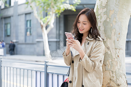 年轻美女拿手机微笑高清图片