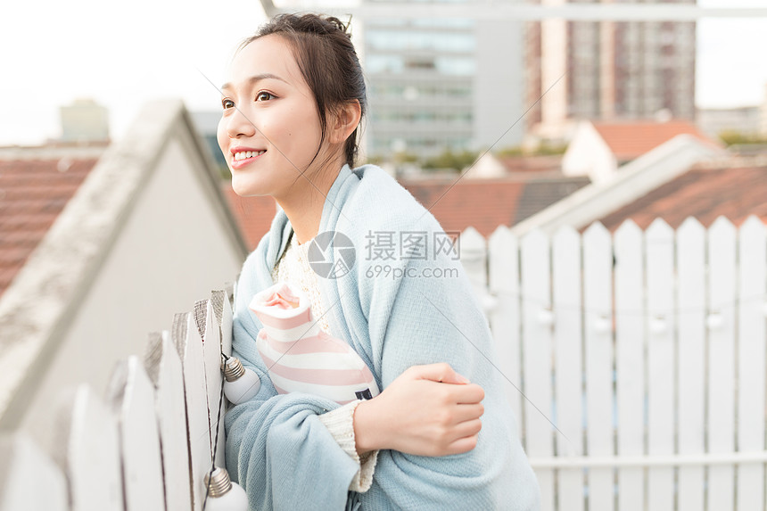 女生抱暖手袋特写图片