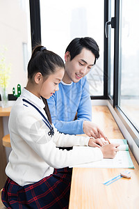 年轻爸爸辅导女儿功课图片素材