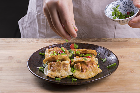 在煎饺上撒葱花高清图片