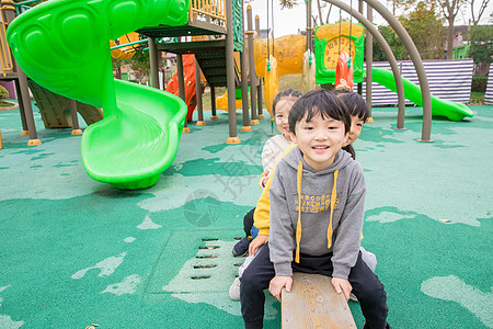 幼儿园儿童玩跷跷板背景图片