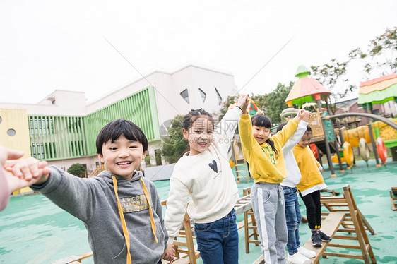 幼儿园儿童牵手过独木桥图片