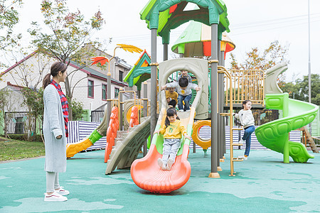 户外幼师带儿童玩滑滑梯背景图片