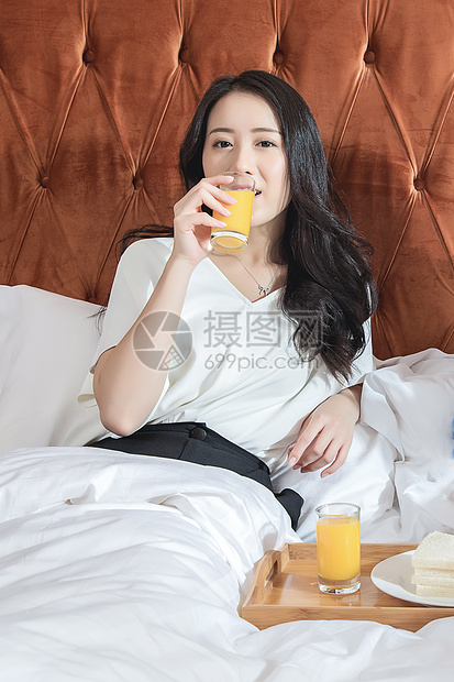 酒店客房吃早餐的女性图片