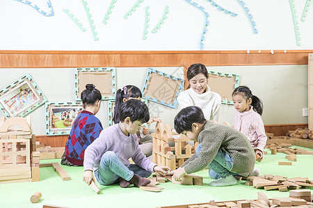 戴眼镜小孩幼儿园老师带小朋友玩积木背景