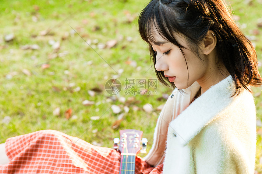文艺女性草坪弹吉他图片