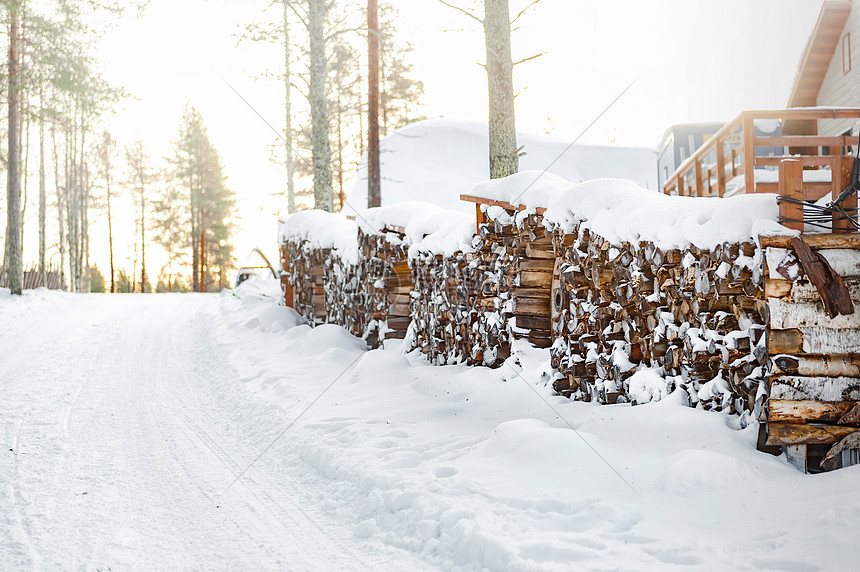 北欧芬兰洛瓦涅米圣诞老人村雪地里的柴火堆图片