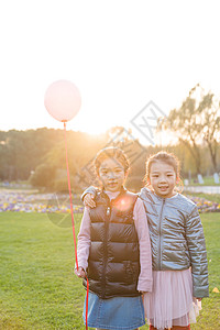 夕阳下拿着气球的女孩们图片