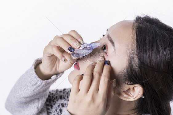 滴眼药水的女性图片