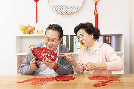 奶奶教爷爷剪窗花背景图片