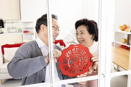 爷爷奶奶一起贴窗花背景图片