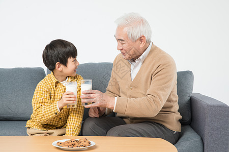 儿童牛奶祖孙沙发上喝牛奶吃早餐背景
