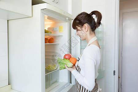 从冰箱里拿果蔬的家庭主妇图片