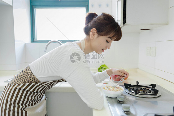 厨房里吃麦片的家庭主妇图片