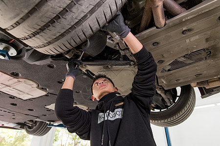 修理工人检查汽车轮胎背景图片