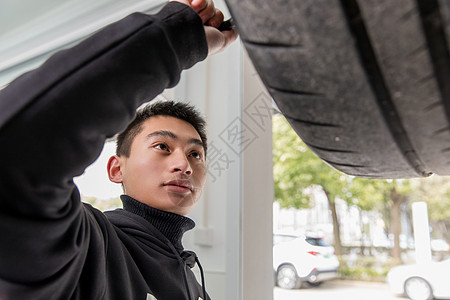 修理工人检查汽车轮胎背景图片