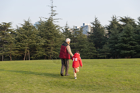 老年人 夕阳祖孙情爷爷牵孙子散步背影背景