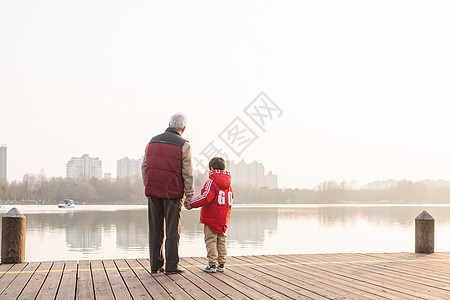 祖孙情夕阳下爷爷牵孙子背影高清图片