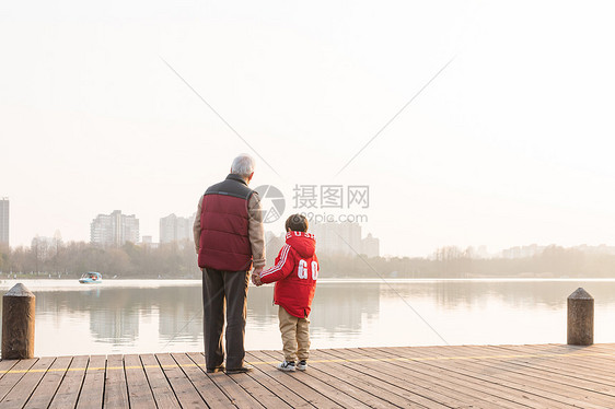 祖孙情夕阳下爷爷牵孙子背影图片