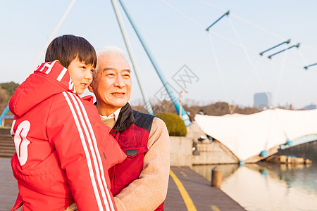 祖孙情夕阳下爷爷抱孙子看风景背景图片