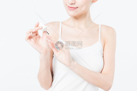 女性美甲涂指甲保护油特写图片