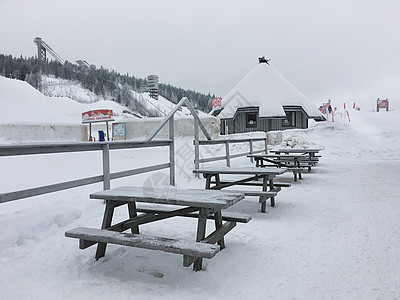 芬兰洛瓦涅米冰雪世界里的木桌椅高清图片