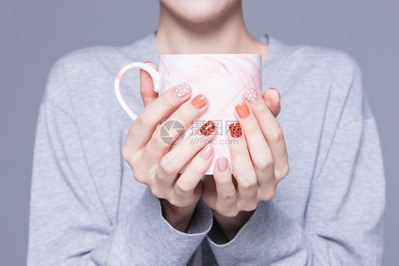 女性美甲手捧水杯特写图片